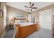 Cozy bedroom with wooden bed, ceiling fan, neutral carpet, and a painting of sailboats above the bed at 10406 Eastwood Dr, Bradenton, FL 34211