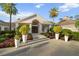 A clubhouse entrance features manicured landscaping, potted plants, and a charming walkway with pavers at 10406 Eastwood Dr, Bradenton, FL 34211
