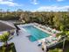 The community pool features ample seating, lush landscaping, and a view of the tennis court at 10406 Eastwood Dr, Bradenton, FL 34211