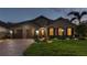 Charming single-story home with a manicured lawn and a brick driveway at dusk at 10406 Eastwood Dr, Bradenton, FL 34211