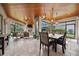 A covered lanai, with travertine tile flooring, a stone fireplace, and wood plank ceilings at 10406 Eastwood Dr, Bradenton, FL 34211