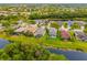 An aerial view shows the neighborhood, backyards, lake, and green spaces, perfect for Gathering and outdoor living at 12211 Lavender Loop, Bradenton, FL 34212