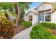 Landscaped front yard with lush greenery, a brick pathway, and a glimpse of the charming facade of the house at 12211 Lavender Loop, Bradenton, FL 34212