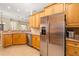 Contemporary kitchen with stainless steel refrigerator, wood cabinets, and granite countertops at 12211 Lavender Loop, Bradenton, FL 34212