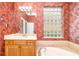 Bright bathroom featuring textured wallpaper, glass block window, vanity and sink at 12211 Lavender Loop, Bradenton, FL 34212