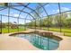 A sparkling pool inside an enclosed lanai offers a serene view of the lush green lawn and tranquil lake at 12211 Lavender Loop, Bradenton, FL 34212