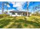 Well-maintained exterior with lush lawn and mature trees enhancing curb appeal at 12495 Patsy Ave, Port Charlotte, FL 33981
