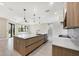Open-concept kitchen featuring a large center island with sink and stainless steel appliances at 12495 Patsy Ave, Port Charlotte, FL 33981