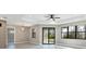 Main bedroom featuring tray ceiling, stylish ceiling fan, and sliding glass door at 12495 Patsy Ave, Port Charlotte, FL 33981