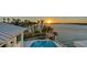 Overhead view of home featuring lush backyard with palm trees, pool, and waterfront access at sunset at 1300 Tangier Way, Sarasota, FL 34239