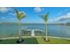 Scenic backyard with a well maintained lawn, palm trees, and dock at 1300 Tangier Way, Sarasota, FL 34239