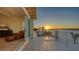 Spacious balcony with water views and direct access to the home's living room and a cozy chair with footstool at 1300 Tangier Way, Sarasota, FL 34239