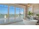 Bathroom with soaking tub overlooking water, sliders to a balcony, and statement lighting at 1300 Tangier Way, Sarasota, FL 34239