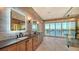 Bright bathroom with dual sinks, wood-look tile, and sliders overlooking the water at 1300 Tangier Way, Sarasota, FL 34239