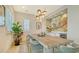 Bright dining room featuring a large table, custom art, modern lighting, and a wet bar with beverage center at 1300 Tangier Way, Sarasota, FL 34239