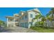 Elegant two-story home with a three-car garage, accented by blue shutters and lush landscaping at 1300 Tangier Way, Sarasota, FL 34239