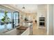 Modern kitchen with large farmhouse sink, stainless steel appliances, and breakfast bar with a view of the water at 1300 Tangier Way, Sarasota, FL 34239