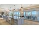 Spacious kitchen with an island bar, stainless steel appliances, and an adjacent outdoor dining area at 1300 Tangier Way, Sarasota, FL 34239