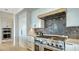 Chef's kitchen featuring a stainless steel range, custom backsplash, white cabinetry, and modern appliances at 1300 Tangier Way, Sarasota, FL 34239