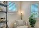 Cozy armchair sits in a sunny room with a leafy plant and classic window shutters at 1300 Tangier Way, Sarasota, FL 34239