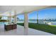 Covered patio with seating and a pool overlooking the waterfront at 1300 Tangier Way, Sarasota, FL 34239