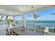 Covered patio with a dining table that overlooks the waterfront at 1300 Tangier Way, Sarasota, FL 34239