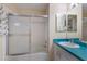 Well-maintained bathroom with a glass-enclosed shower, large mirror, and turquoise countertop at 1528 43Rd Avenue W Dr, Palmetto, FL 34221