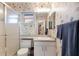 A clean bathroom showcasing a glass door shower, seashell wallpaper, and white vanity at 1528 43Rd Avenue W Dr, Palmetto, FL 34221