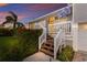 Charming front porch with wood stairs, a welcoming yellow door, and lush landscaping at 1528 43Rd Avenue W Dr, Palmetto, FL 34221