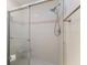 A newly renovated shower with a glass door, light pink stripe, and a shower head at 1528 43Rd Avenue W Dr, Palmetto, FL 34221