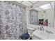 Bathroom highlighting decorative, marine-themed shower curtains and a white sink and toilet at 16211 Rambling Vine W Dr, Tampa, FL 33624