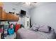 Bedroom featuring tile floors, a TV, mini-fridge, and a view into the en-suite bathroom at 16211 Rambling Vine W Dr, Tampa, FL 33624