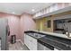 Open kitchen with stainless steel appliances and bar overlooking laundry area at 16211 Rambling Vine W Dr, Tampa, FL 33624