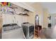 Laundry room featuring modern washer and dryer, coat rack, and built-in shelving at 16211 Rambling Vine W Dr, Tampa, FL 33624