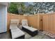 Back patio featuring lounge chairs with white cushions and a wood privacy fence at 16211 Rambling Vine W Dr, Tampa, FL 33624