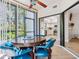 Dining area features a round wooden table with blue chairs and an open view of the kitchen with white cabinetry at 1680 Starling Dr # 101, Sarasota, FL 34231