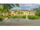 Inviting exterior view of yellow townhouse with a red tile roof, palm trees, and parking spaces at 1685 Laurel St # 4, Sarasota, FL 34236