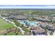 Aerial shot of a community pool featuring lush landscaping, a waterfall, and various lounge areas at 17448 Hickok Belt Loop, Bradenton, FL 34211