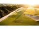 Scenic aerial view of golf course showcasing the green, sand traps, and bordering vegetation at 17448 Hickok Belt Loop, Bradenton, FL 34211