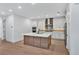 Modern kitchen with white cabinets, stainless steel appliances, large island, and stylish backsplash at 18803 Dayspring Pl, Venice, FL 34293