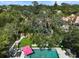 An aerial view of a private backyard oasis with a refreshing pool, lush greenery, and comfortable lounge seating at 1939 Baywood Pl, Sarasota, FL 34231