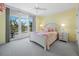 Bright bedroom with a balcony access, complemented by a white-painted wooden bed frame and pastel decor at 2410 Harbourside Dr # 121, Longboat Key, FL 34228