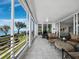 Extended lanai with comfortable lounge seating and panoramic views of the bay and the trees at 2410 Harbourside Dr # 121, Longboat Key, FL 34228