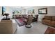 Spacious living room with large windows, a comfortable brown leather sectional and tiled flooring at 2410 Harbourside Dr # 121, Longboat Key, FL 34228