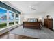 Bright main bedroom featuring a large window with picturesque water views, wooden floors, and a ceiling fan at 2410 Harbourside Dr # 121, Longboat Key, FL 34228