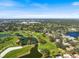 Beautiful aerial view of the lush community featuring mature trees, ponds, and landscaping at 26833 Weiskopf Dr, Englewood, FL 34223