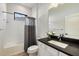 Bright bathroom showcasing a vanity with a dark countertop and a shower-tub combination at 26833 Weiskopf Dr, Englewood, FL 34223
