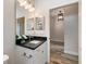 Well-lit bathroom featuring a single vanity with a dark countertop and classic fixtures at 26833 Weiskopf Dr, Englewood, FL 34223