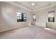 A large bedroom with carpet flooring and natural light from windows and minimalist decor at 26833 Weiskopf Dr, Englewood, FL 34223