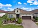 Charming single-story home featuring a barrel tile roof, brick-paved driveway, and a well-manicured lawn at 26833 Weiskopf Dr, Englewood, FL 34223